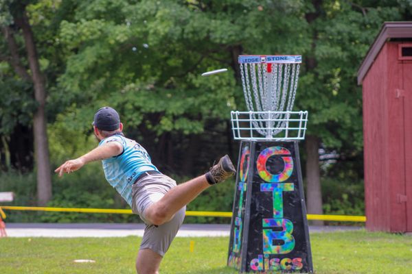 Disc golfer mid-throw on the course